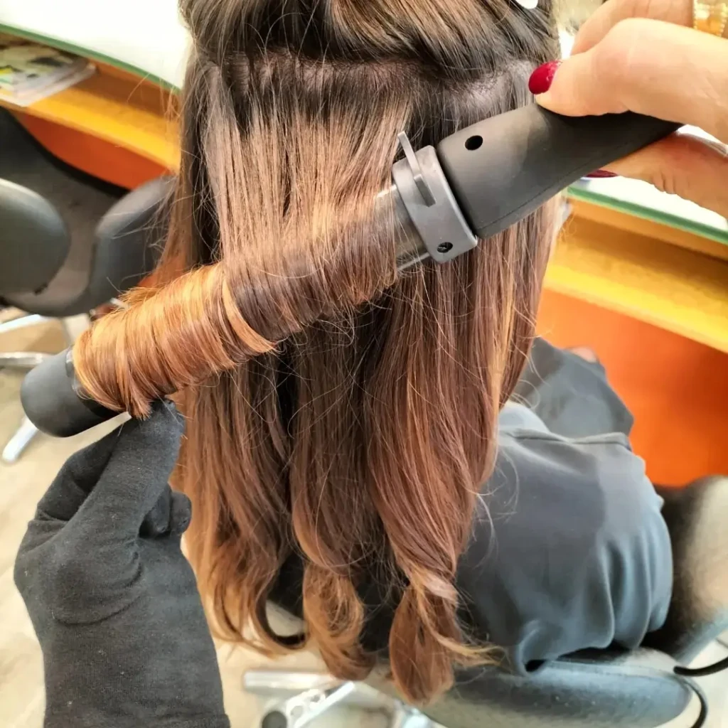Réalisation d'un ombré cuivré sur cheveux longs avec brushing wavy dans notre salon de coiffure pour femmes à Bordeaux.